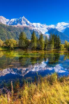  The lake reflected the snow-capped Alps and  spruce. Early autumn in Chamonix, Haute-Savoie. France