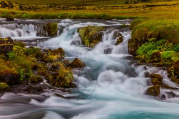 Powerful cascading waterfalls in Iceland. Wide picturesque valley along highway number one around the island. Concept of active and extreme tourism