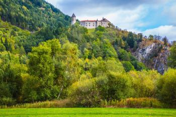 Medieval castle on the crest of the mountain. The concept of ecological tourism. Charming green   forest of the mountain. Val de Funes, Dolomites. Warm autumn day