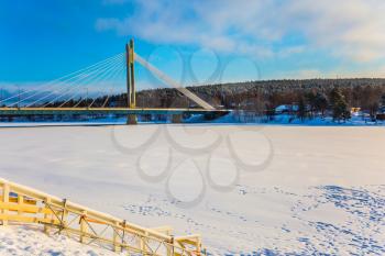 The bridge and the frozen river Kemijoki in the tourist town of Rovaniemi, Lapland.  The Arctic Circle. Concept of active winter tourism
