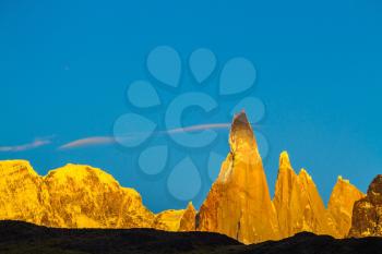 Fiery sunset illuminates the majestic mountains - rock Fitz Roy. Thd stunning Patagonia
