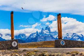 Symbolic columns at the entrance to Los Glaciares National Park. Fine highway to the grandiose Mount Fitz Roy. Patagonian pampas. The concept of active and ecological tourism
