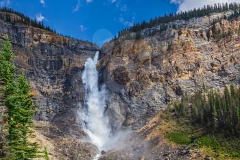 Autumn in Yoho National Park in the Rocky Mountains of Canada.  The tremendous falls Takakkaw. Mist from the huge waterfall scatters in all directions