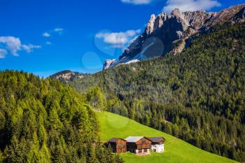 Lovely autumn day. Dolomites, Val de Funes valley. Picturesque mountains surround the green alpine meadows of the valley