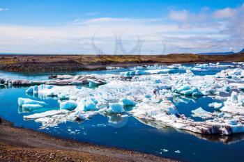 White-blue ice is piled up in turquoise water of Jokulsarlon. The concept of extreme northern tourism