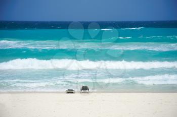 Beach chairs on the beach facing Cancun's Caribbean Sea
