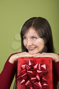 Royalty Free Photo of a Woman Leaning on a Christmas Gift