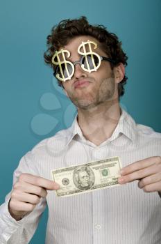 Royalty Free Photo of a Guy in Dollar Sign Sunglasses Holding a Dollar Bill