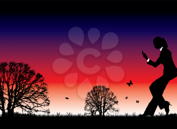 Royalty Free Clipart Image of a Woman Making a Call Against a Sunset
