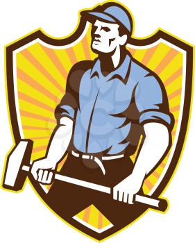 Illustration of a union worker with sledgehammer hammer done in retro style set inside shield crest with sunburst on isolated white background.
