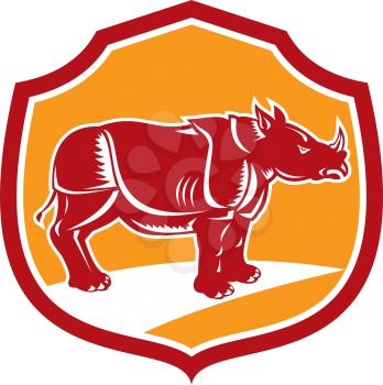 Illustration of a rhinoceros standing side view set inside shield crest on isolated background done in retro style.