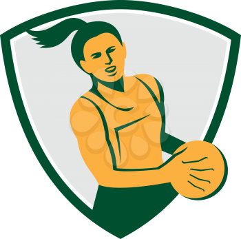 Illustration of a netball player holding ball viewed from front set inside shield crest on isolated white background done in retro style. 