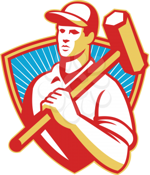 Illustration of a construction worker with sledgehammer on shoulder set inside shield done in retro style.