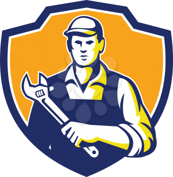 Illustration of a mechanic wearing hat holding adjustable wrench facing front set inside shield crest on isolated background done in retro style. 