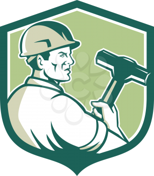 Illustration of a demolition worker wearing hardhat holding sledgehammer viewed from the side set inside shield crest on isolated background done in retro style. 