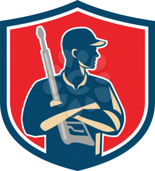 Illustration of power washer worker with arms crossed holding pressure washing gun looking to the side viewed from front set inside shield crest on isolated background done in retro style. 