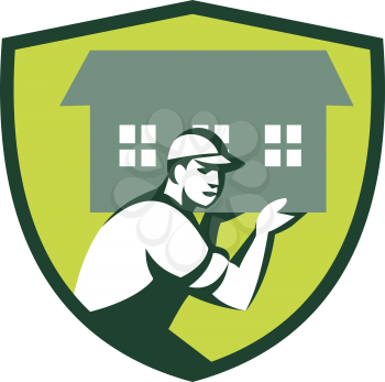 Illustration of a house remover carrying house on shoulder viewed from the side   set inside shield crest` done in retro style. 