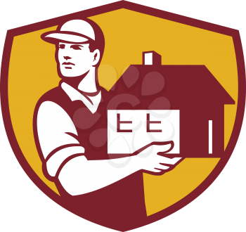Illustration of a house mover handling holding house looking to the side set inside shield crest on isolated background done in retro style. 