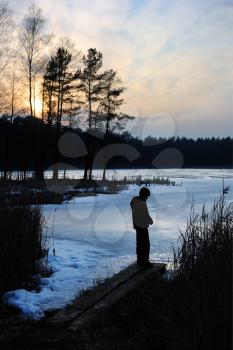 Royalty Free Photo of a Boy at the Edge of a Frozen Lake