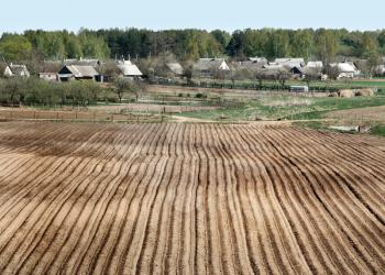 Royalty Free Photo of a Village and Plowed Field