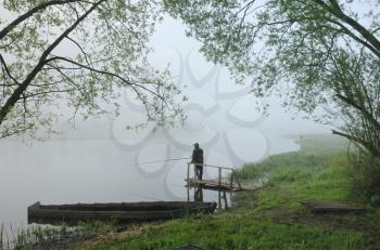 Royalty Free Photo of a Fisherman in the Fog