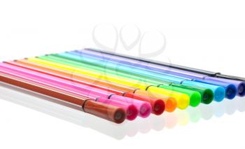Multi-colored felt pen and their reflection in the glass surface, isolated
