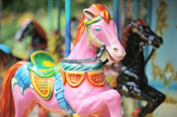 Pink and black horses on the carousel in City Park
