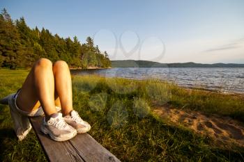 Royalty Free Photo of a Woman Lying on a Railing Near Water