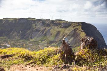 Dramatic Volcano crater near Orongo vilage, Easter Island, grassy walls, sharp rocks, endless ocean