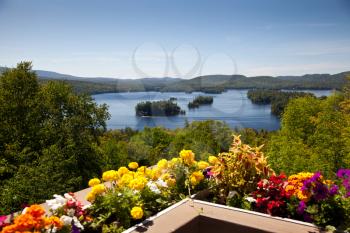 Beautiful colorful view on the mountains lake from balcony with yellow and red flowers
