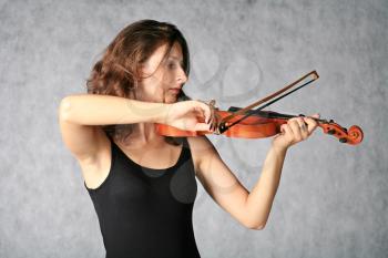 portrait of sexy brunette with violin on the grey background