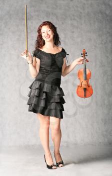 portrait of sexy redhead with violin on the grey background