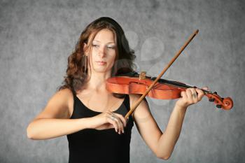 portrait of sexy brunette with violin on the grey background