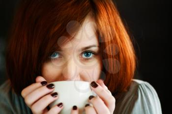 Young Woman Drinking Coffee At Home In Her Kitchen