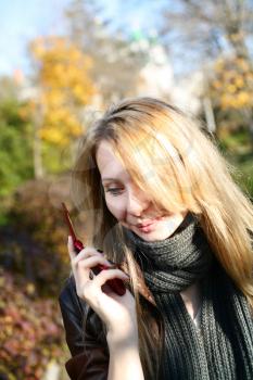 blond woman making a phone call outdoors (nature)