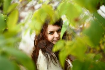 Portrait of a redheaded girl near a tree