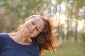 Young redhead woman in the park having fun