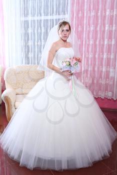 Happy bride with a bouquet of roses. Indoors