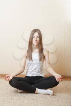 Young Blond Woman do yoga indoors. Fitness concept for health club