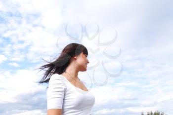 beautiful long hair brunette woman  aganst sky summer day portrait