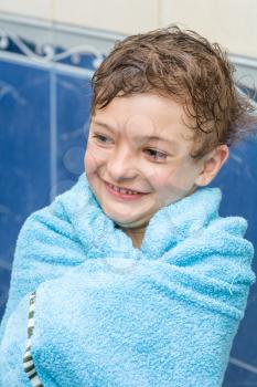 boy after bath warped in blue towel