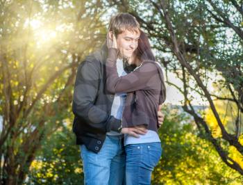 Portrait of a happy couple embracing while in the park. Love tenderness concept