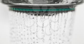 Photograph of a shower head water drops with bokhe sparkles and streams of water.