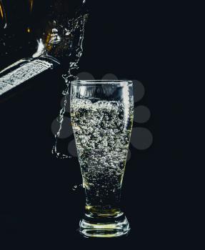pouring drink in shot glass on black