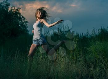 Happy girl jumping in grass. Blurre motion image