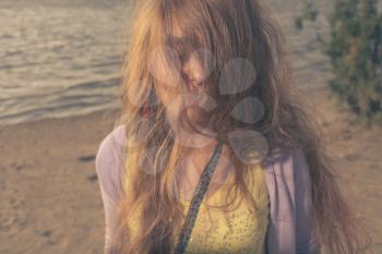 Mysterious looking blonde women outdoors toned image