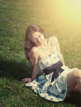 Brunette on grass and a lot of  copyspace