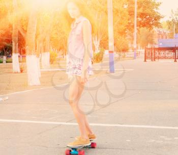 Young  beautiful caucasian skater woman during the sunset, outdoor backlit