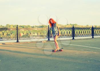 Skater caucasian women on skateboard at sunrise.