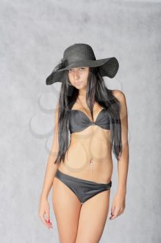 SExy young women in black hat and bikini studio shot